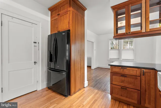 a kitchen with stainless steel appliances granite countertop wooden cabinets and a refrigerator
