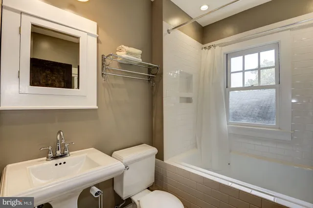 a bathroom with a sink mirror and toilet