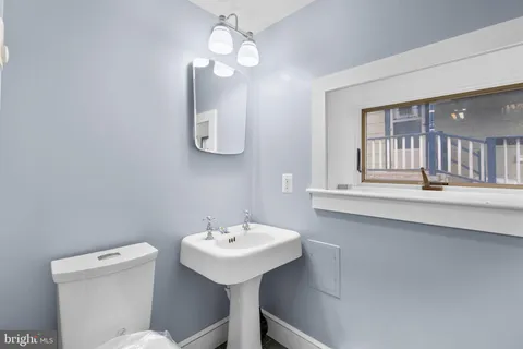 a bathroom with a toilet a sink and mirror