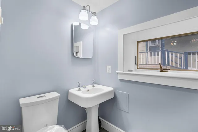 a bathroom with a toilet a sink and mirror