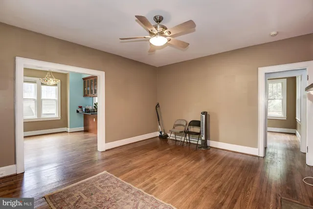 a view of a livingroom with wooden floor and a ceiling fan