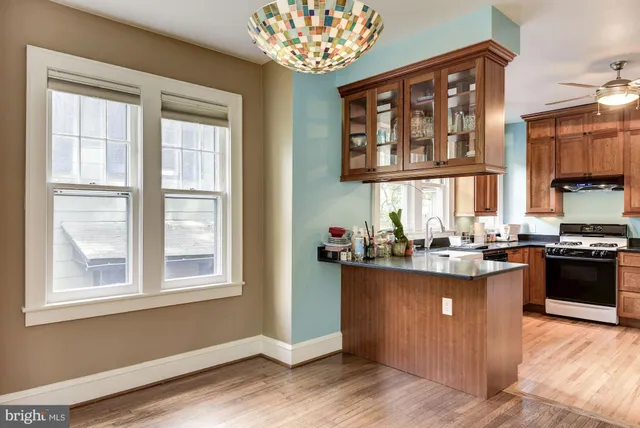 a kitchen with a stove and a wooden floor