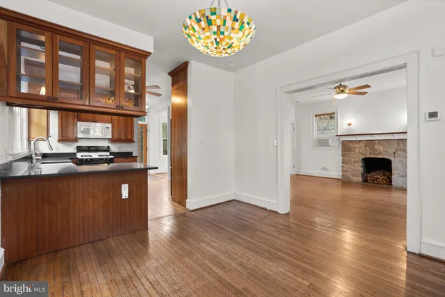 a kitchen with kitchen island granite countertop a stove top oven a sink and a microwave