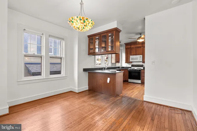 a kitchen with stainless steel appliances granite countertop a sink cabinets and wooden floor