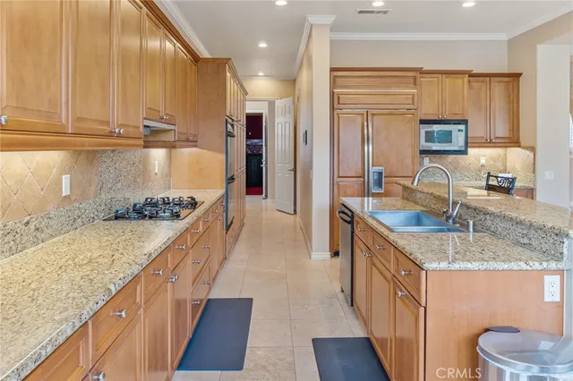 a kitchen with granite countertop a refrigerator and cabinets