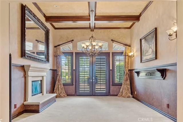 a view of an empty room with a fireplace and a chandelier