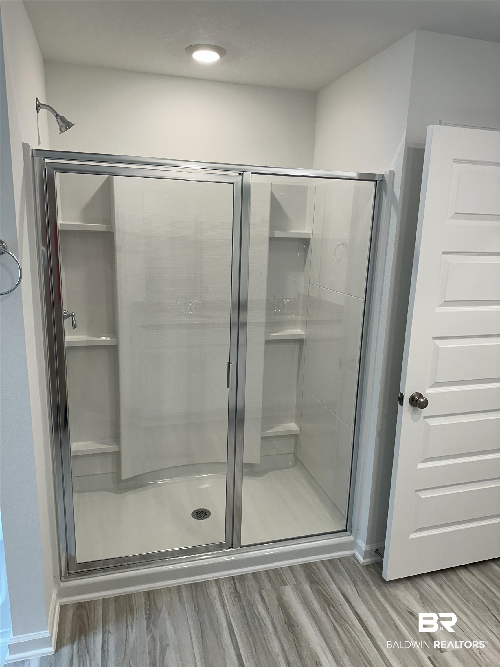 22044 Aleutian Avenue Foley, AL 36535 - Photo 16 of 28 Bathroom featuring hardwood / wood-style flooring and a shower with shower door