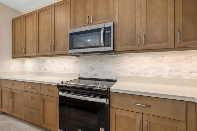 a kitchen with granite countertop cabinets stainless steel appliances and wooden cabinets