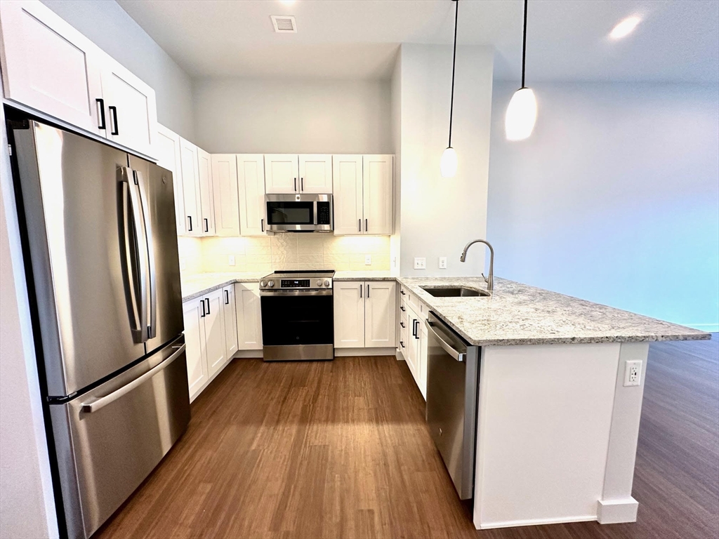 a kitchen with white cabinets sink and stainless steel appliances