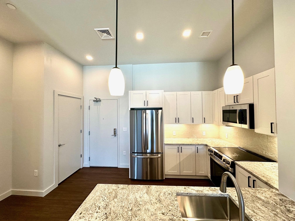 45 East Central Street, Unit 405 Natick, MA 01760 - Photo 3 of 21 a kitchen with stainless steel appliances granite countertop a refrigerator a sink and a stove