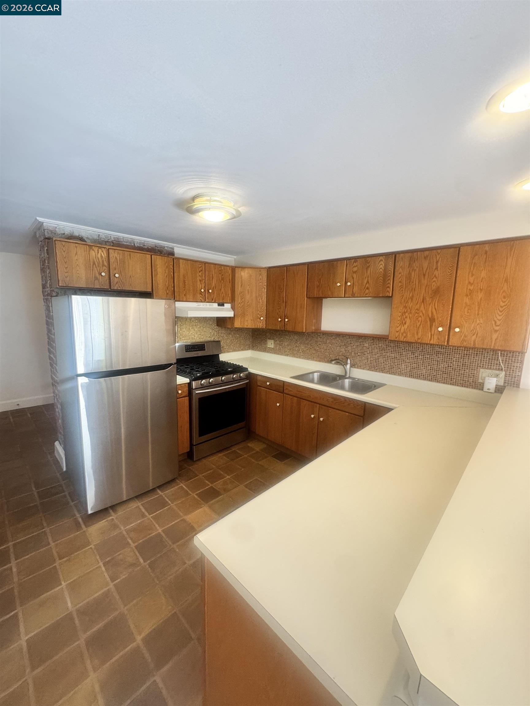 1723 Carleton Street, Unit A Berkeley, CA 94703 - Photo 15 of 32 a kitchen with stainless steel appliances granite countertop a refrigerator a sink a stove and white cabinets