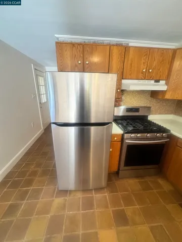 a kitchen with granite countertop a refrigerator and a stove
