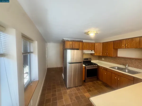 a kitchen that has a sink stainless steel appliances a counter space and a window