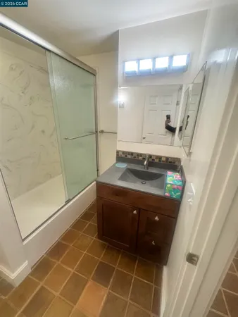 a bathroom with a granite countertop sink toilet and shower