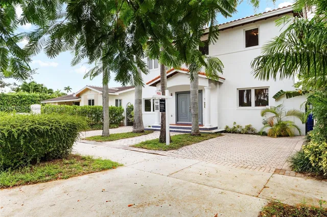 a white house with palm tree in front of it