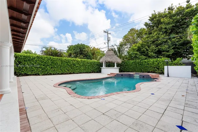a view of yellow house with pool table and chairs