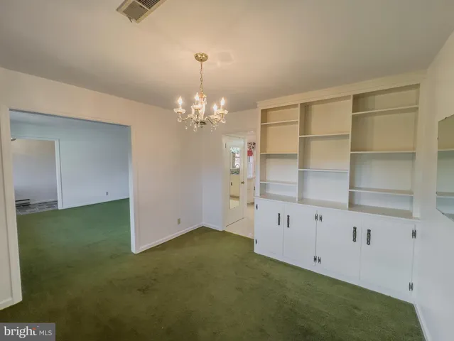 a view of an empty room with a chandelier