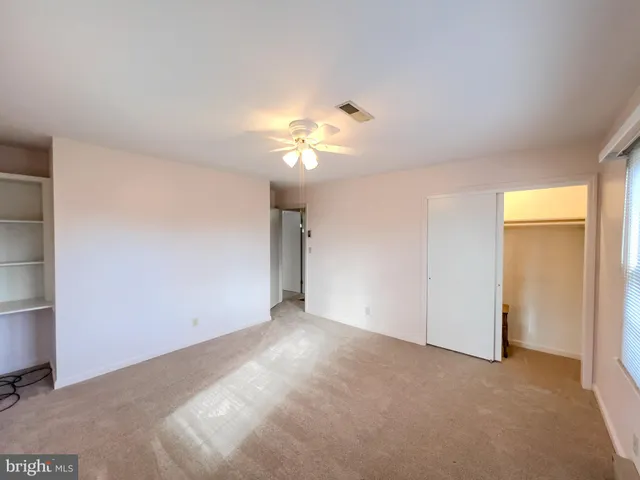 a view of a room with a ceiling fan and a window
