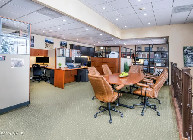 a living room with furniture a rug kitchen view and a chandelier