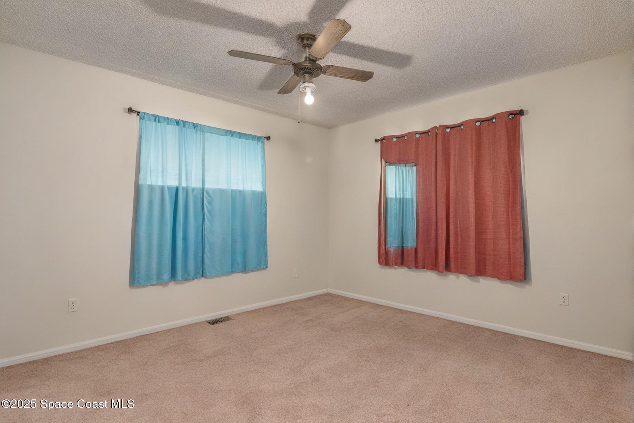 722 Venus Drive Cocoa, FL 32926 - Photo 13 of 17 an empty room with windows and fan