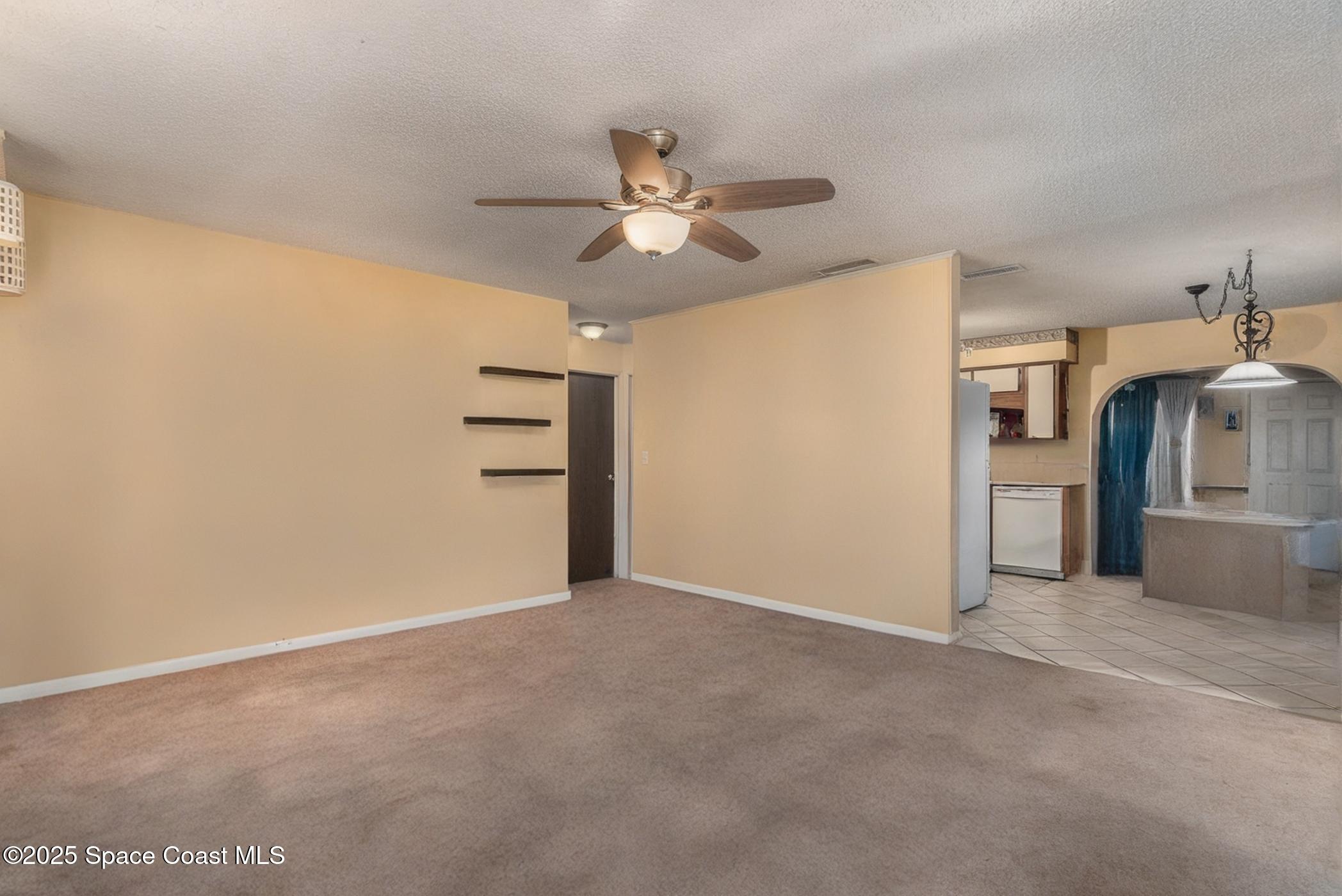 722 Venus Drive Cocoa, FL 32926 - Photo 8 of 17 an empty room with a empty space and a ceiling fan
