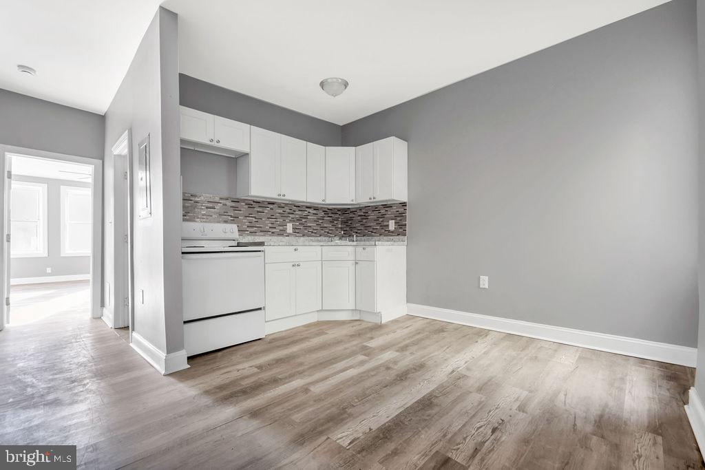 606 South 52nd Street Philadelphia, PA 19143 - Photo 6 of 16 a kitchen with granite countertop white cabinets and white appliances