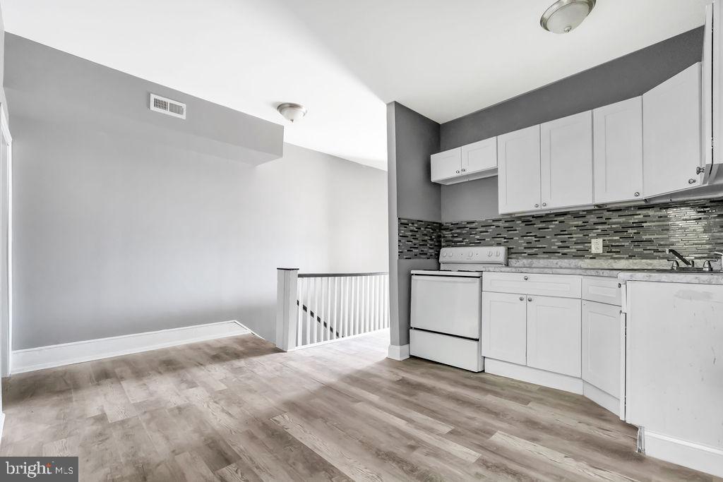606 South 52nd Street Philadelphia, PA 19143 - Photo 8 of 16 a kitchen with granite countertop white cabinets and white appliances