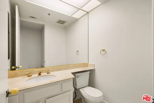 a bathroom with a sink toilet vanity and shower