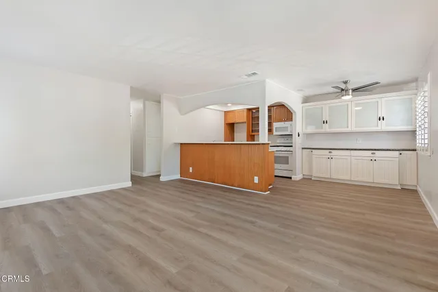 a view of a kitchen with wooden floor and a window
