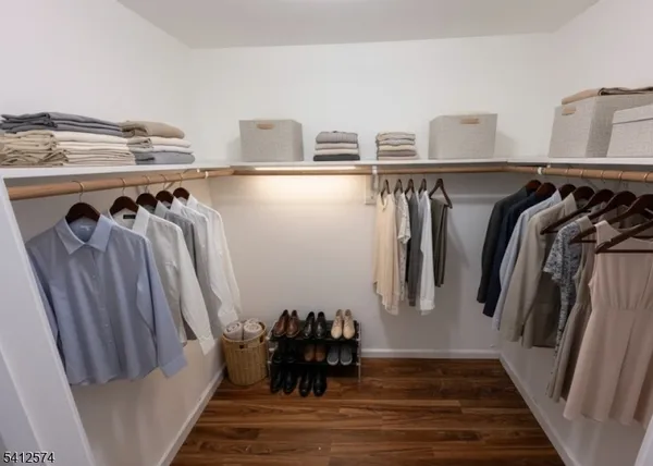 a view of walk in closet with clothes and shoes