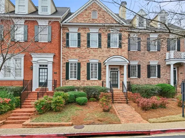 a front view of a house with a yard and potted plants