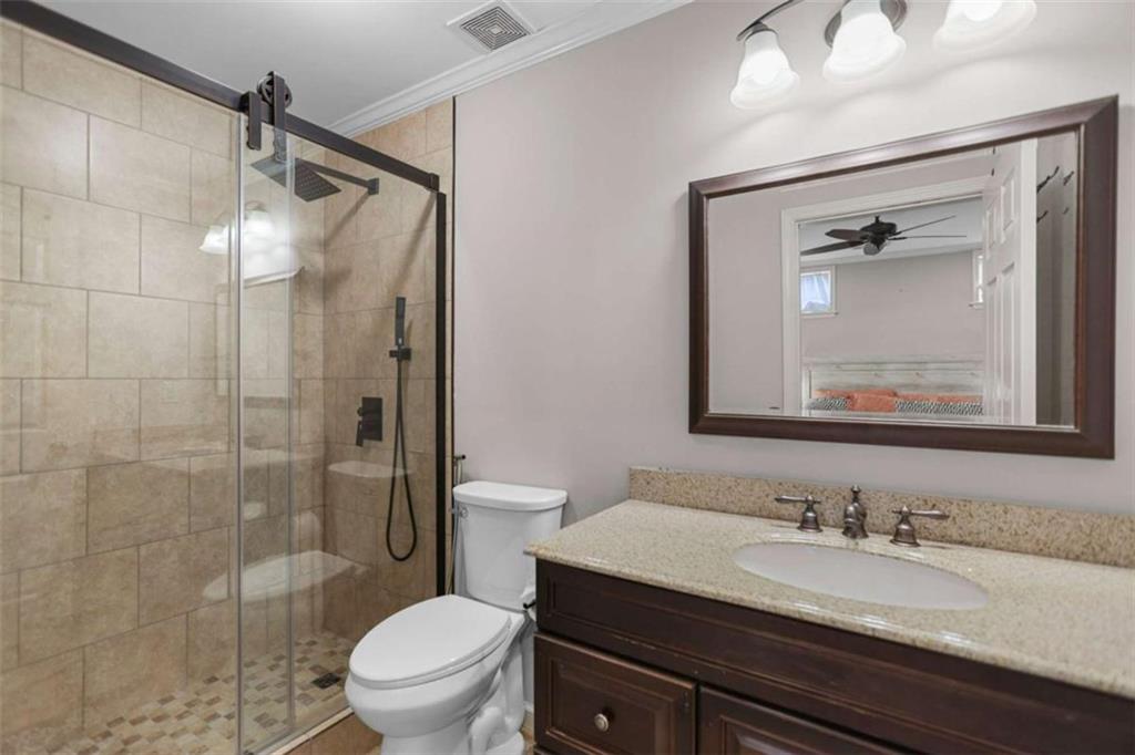 4712 Ivy Ridge Drive Southeast Atlanta, GA 30339 - Photo 29 of 82 a bathroom with a granite countertop sink toilet a mirror and shower