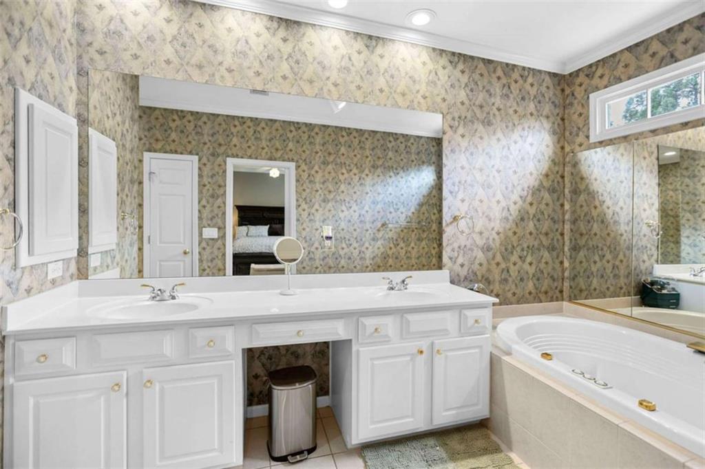 4712 Ivy Ridge Drive Southeast Atlanta, GA 30339 - Photo 34 of 82 a bathroom with a sink a large mirror and a bathtub