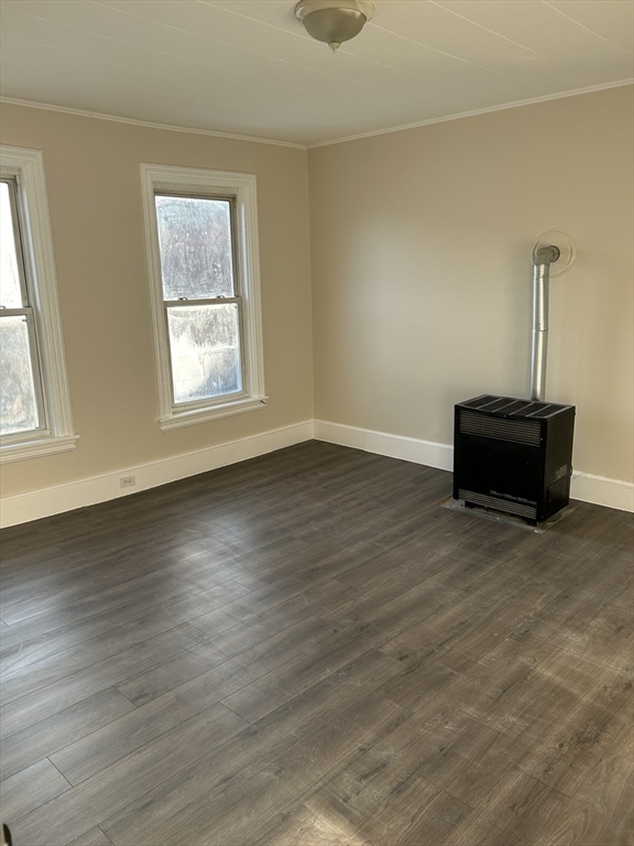 a view of empty room with wooden floor and window