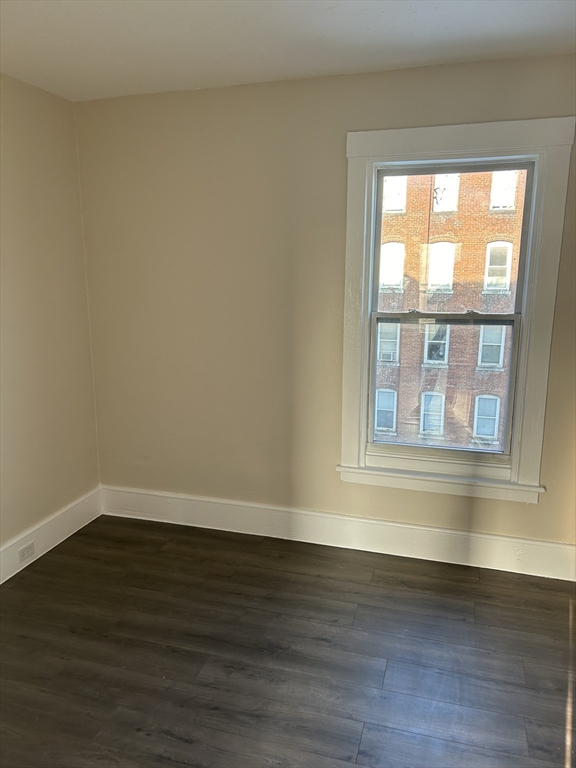 230 Pleasant Street, Unit 2 Worcester, MA 01609 - Photo 3 of 9 a view of an empty room with wooden floor and a window