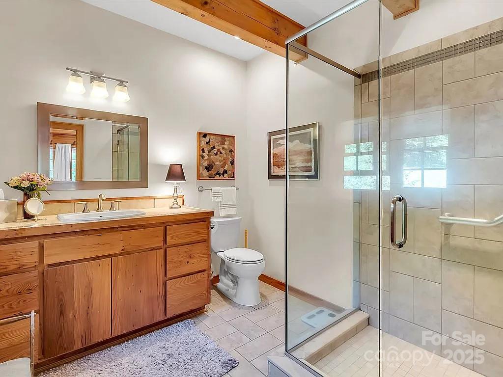 113 Mountain Cove Road Waynesville, NC 28786 - Photo 20 of 48 a spacious bathroom with a double vanity sink toilet mirror and shower