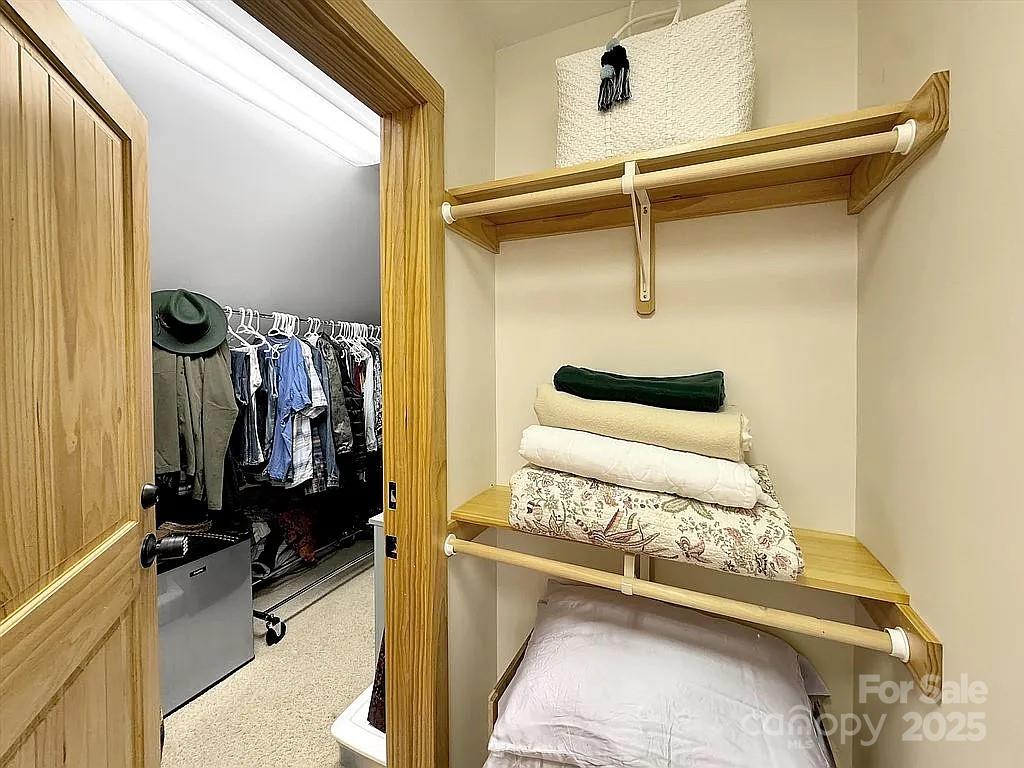 113 Mountain Cove Road Waynesville, NC 28786 - Photo 35 of 48 a view of walk in closet with clothes and shoes