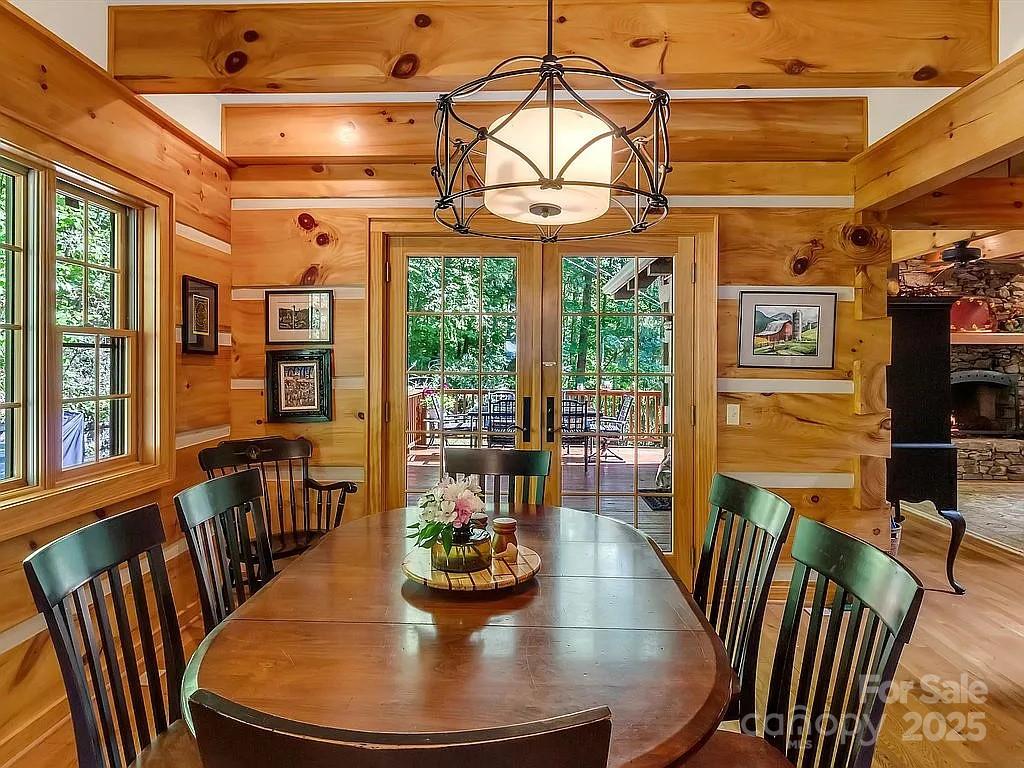 113 Mountain Cove Road Waynesville, NC 28786 - Photo 43 of 48 a view of a dining room with furniture a chandelier and wooden floor