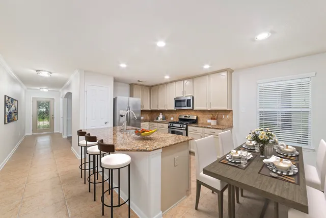 a kitchen with a sink white cabinets and stainless steel appliances