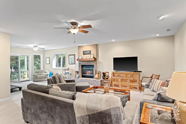 a living room with furniture a fireplace and a flat screen tv