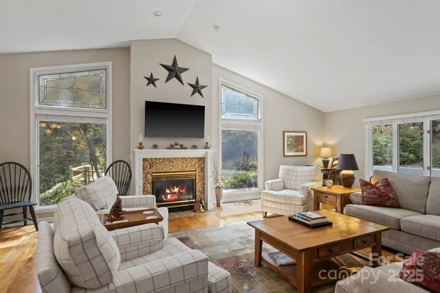 a living room with furniture a fireplace and a flat screen tv