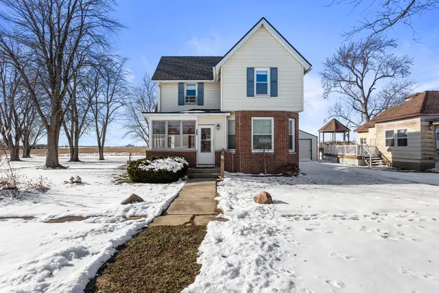 a front view of a house with a yard covered in snow