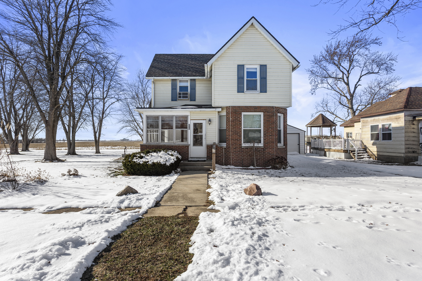 a front view of a house with a yard covered in snow