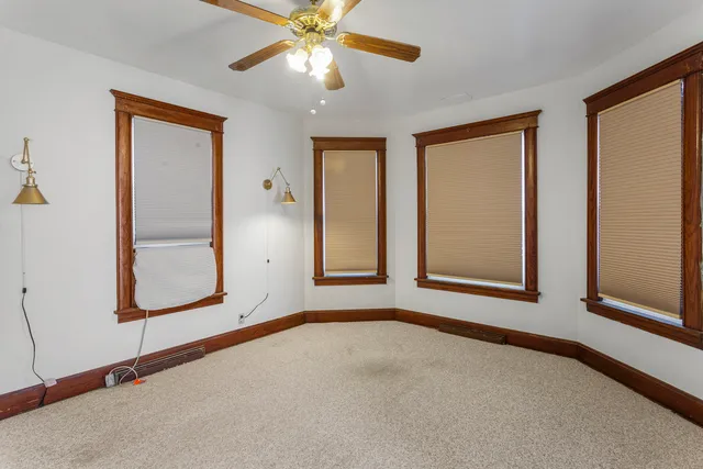 an empty room with windows and fan