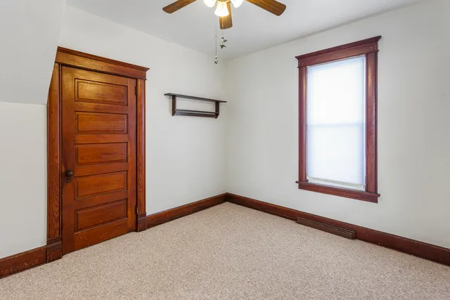 an empty room with closet and a window