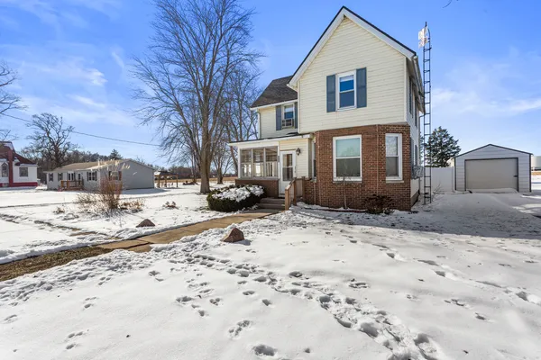 a front view of a house with a yard covered in snow