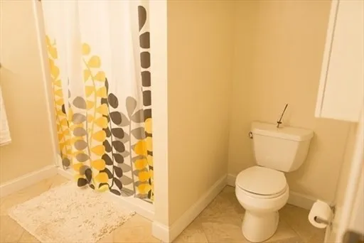a bathroom with a toilet and a shower curtain