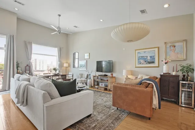 a living room with furniture a large window and a flat screen tv