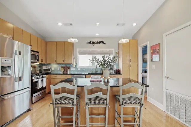 a kitchen with granite countertop appliances and a dining table