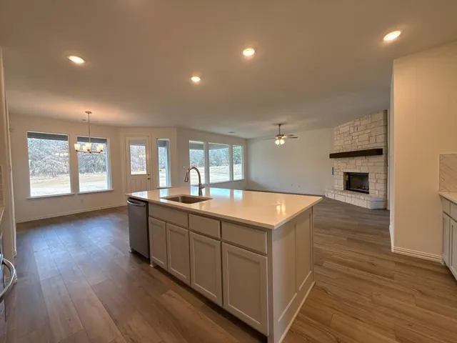 a large kitchen with stainless steel appliances granite countertop a sink and wooden floor